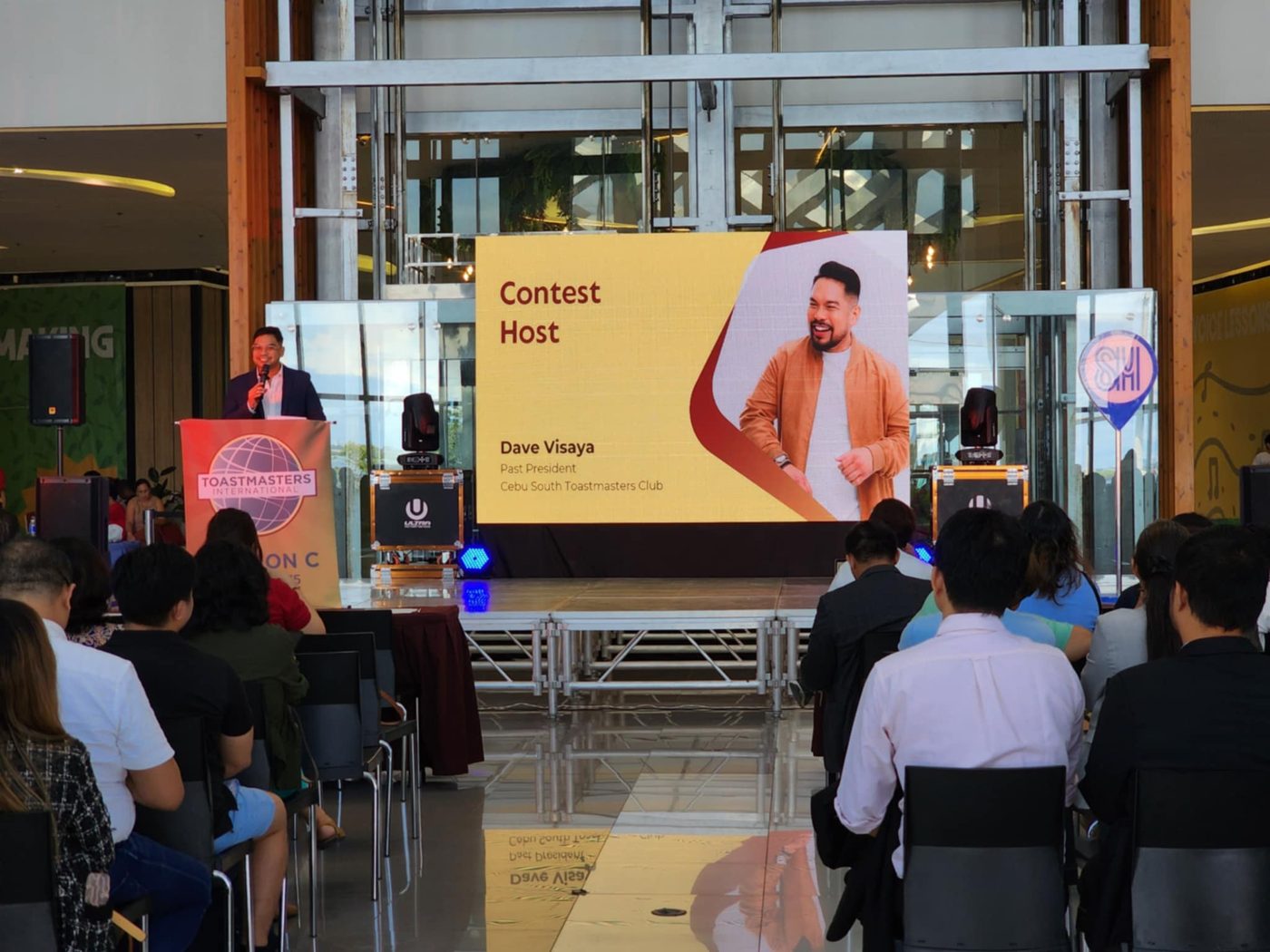 Dave Visaya hosting on stage at a Toastmasters contest